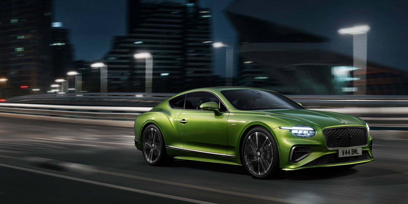 Exclusive Cars Vertriebs GmbH Bentley New Continental GT Speed driving dynamically at night in Tourmaline Green paint