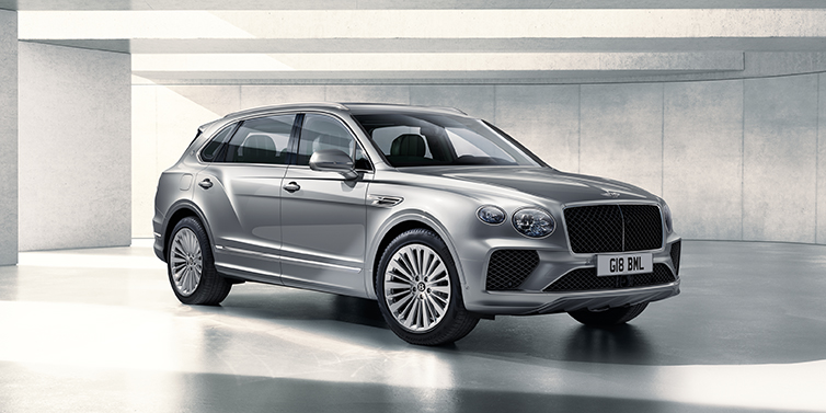 Exclusive Cars Vertriebs GmbH Bentley Bentayga Extended Wheelbase SUV front three quarter in Moonbeam paint with a grey background