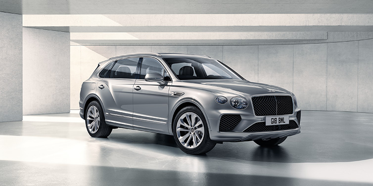 Exclusive Cars Vertriebs GmbH Bentley Bentayga Extended Wheelbase SUV front three quarter in Moonbeam paint with a grey background