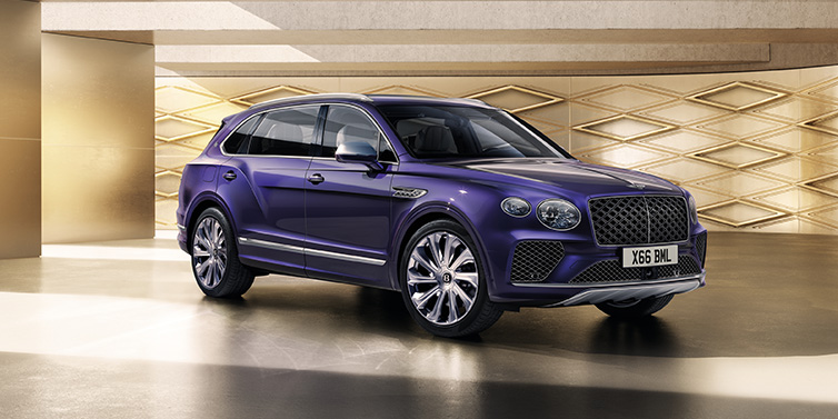 Exclusive Cars Vertriebs GmbH Bentley Bentayga Extended Wheelbase Mulliner SUV front three quarter in Tanzanite Purple paint with a gold patterned background