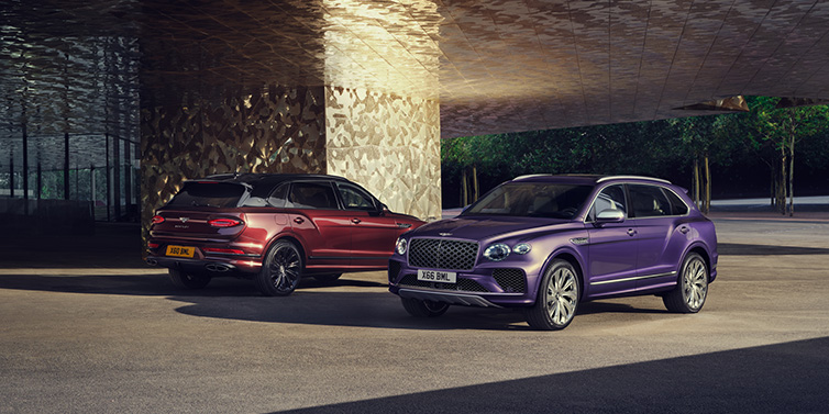 Exclusive Cars Vertriebs GmbH A duo of Bentley Bentayga Extended Wheelbase Mulliner SUVs parked in a city environment, with Tanzanite Purple and Cricket Ball red exterior paint