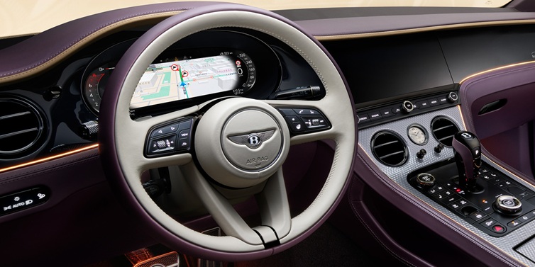 Exclusive Cars Vertriebs GmbH Bentley Continental GT Mulliner coupe front interior showing steering wheel and drivers screens surrounded by Linen and Damson hides and Grand Black veneer